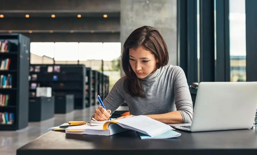 Female writing in the library