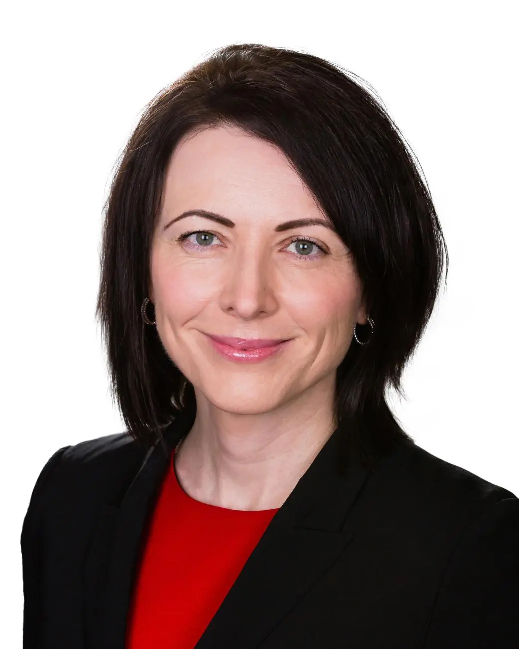 A professional woman in a black blazer and red top smiling, representing Statera Financial Planners.