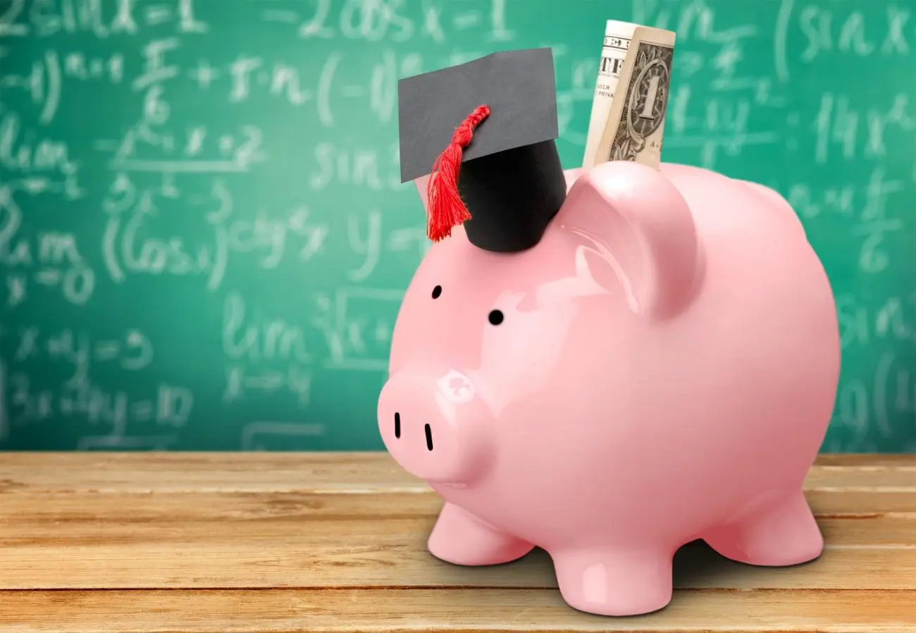 Piggy bank with dollar bill and graduation cap, representing financial planning from Statera Financial Planners.