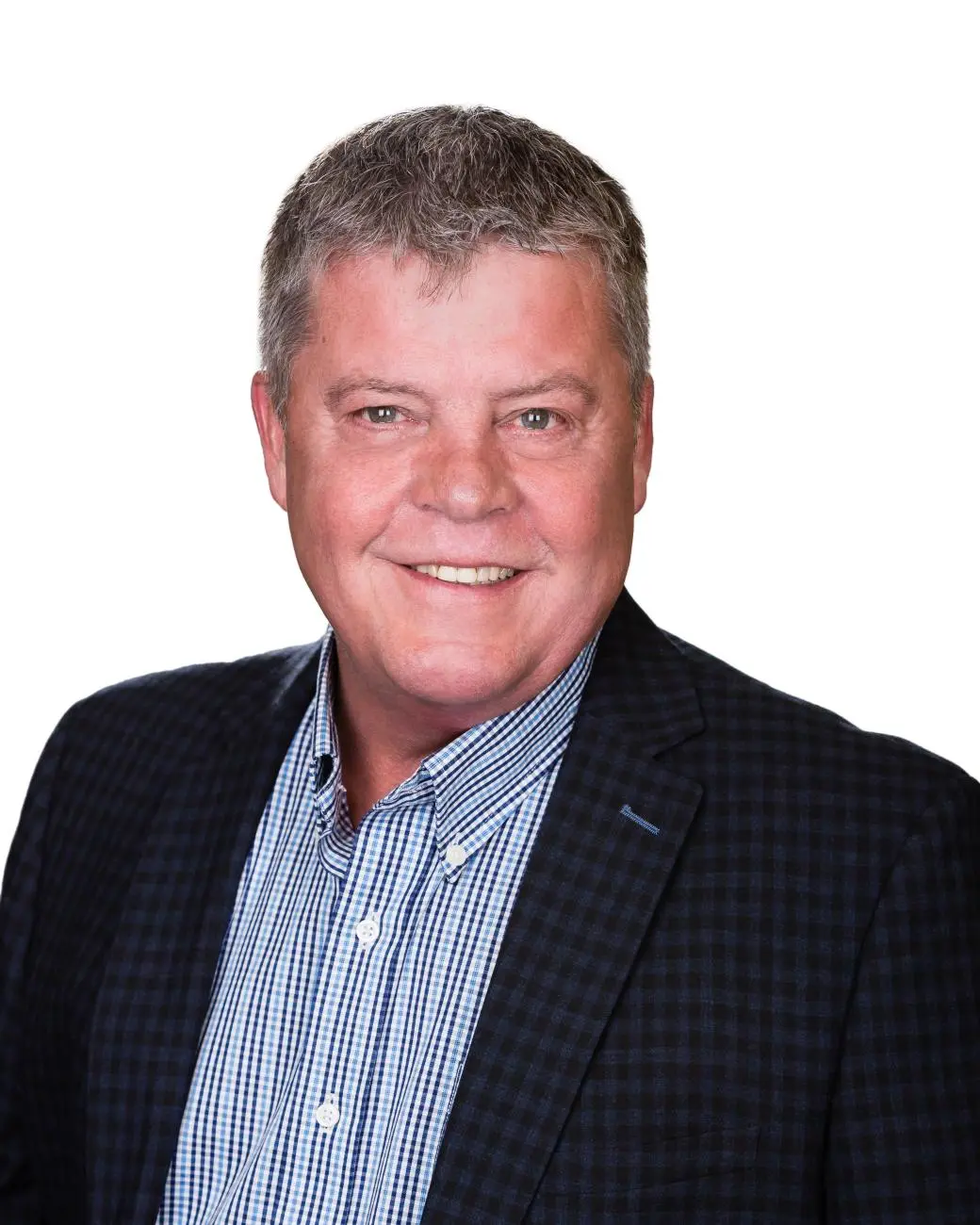 Smiling middle-aged financial advisor Tim Shmigelsky in a dark blazer and blue shirt on a plain white background.